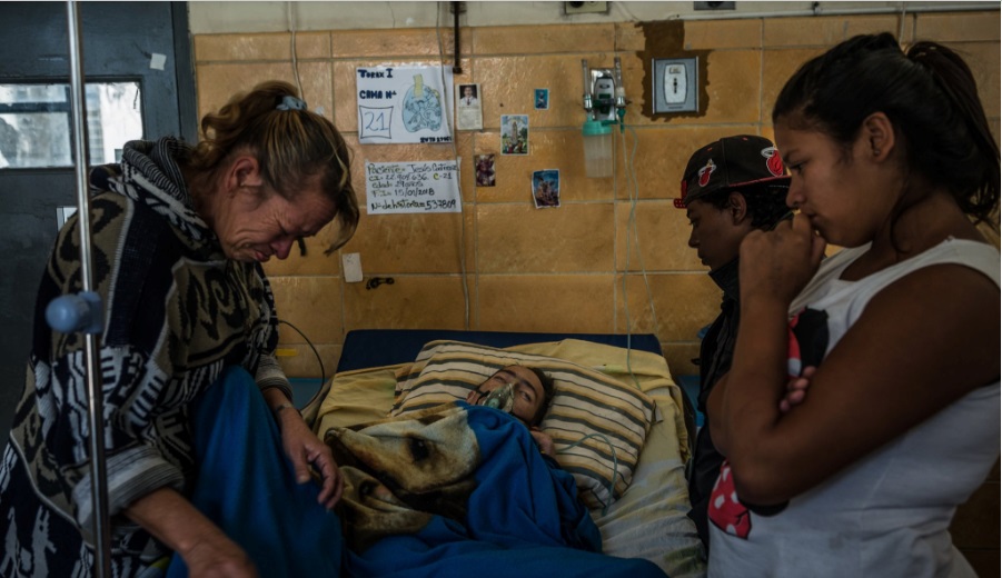 Jesús Contreras, 29, with family and friends in the tuberculosis ward of the Dr. José Ignacio Baldó Hospital in Caracas last month. Credit Meridith Kohut for The New York Times