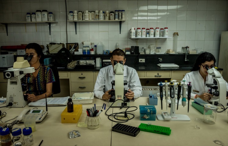 Bioanalysts conducting tuberculosis lab tests at the Institute of Biomedicine. Credit Meridith Kohut for The New York Times